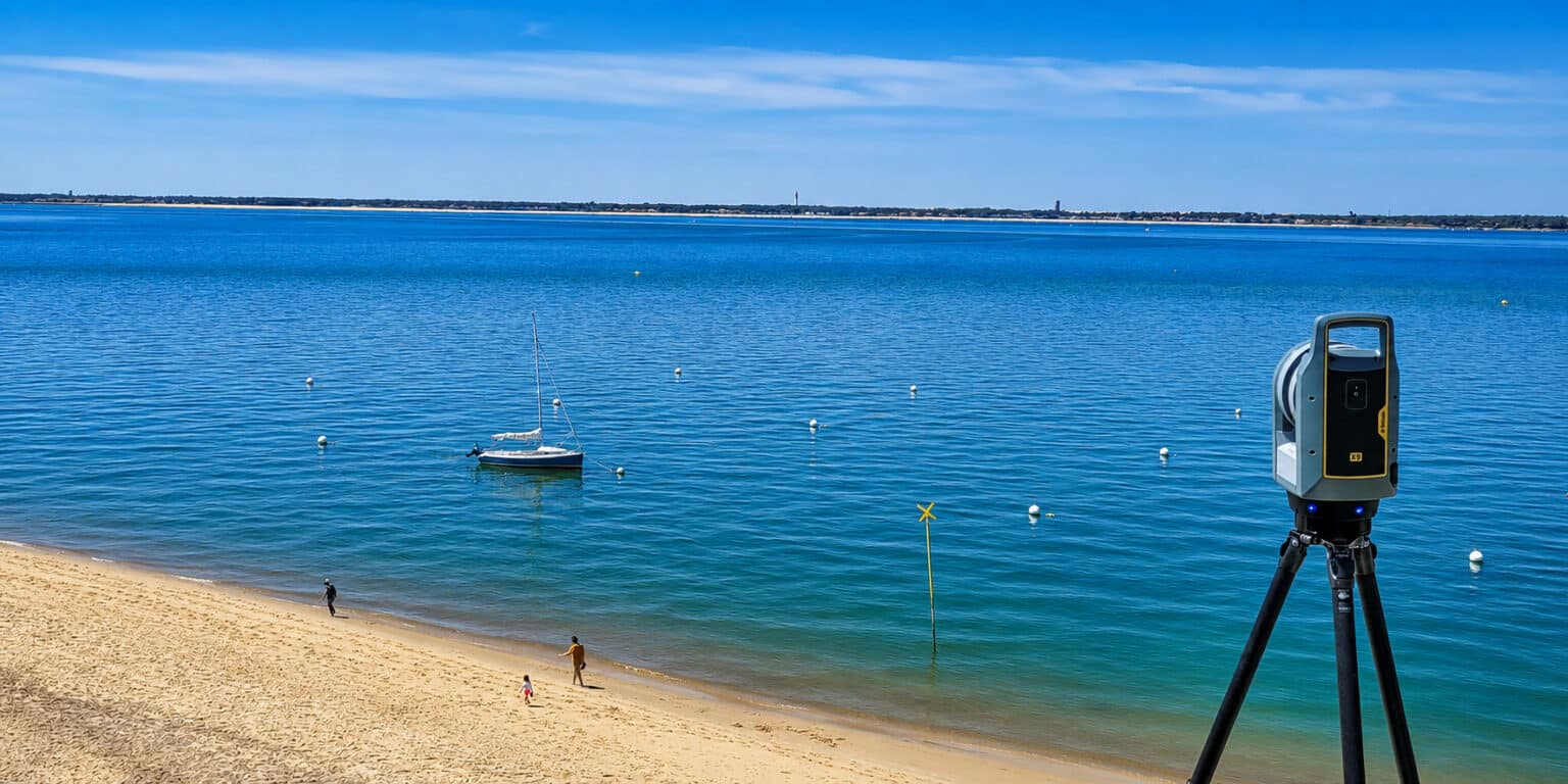 Un scanner laser TRIMBLE X9 sur la plage au Pyla avec le cap ferret en face.